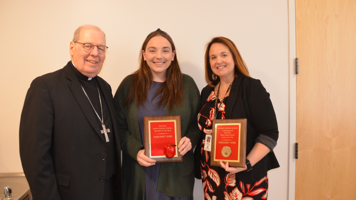three people holding awards