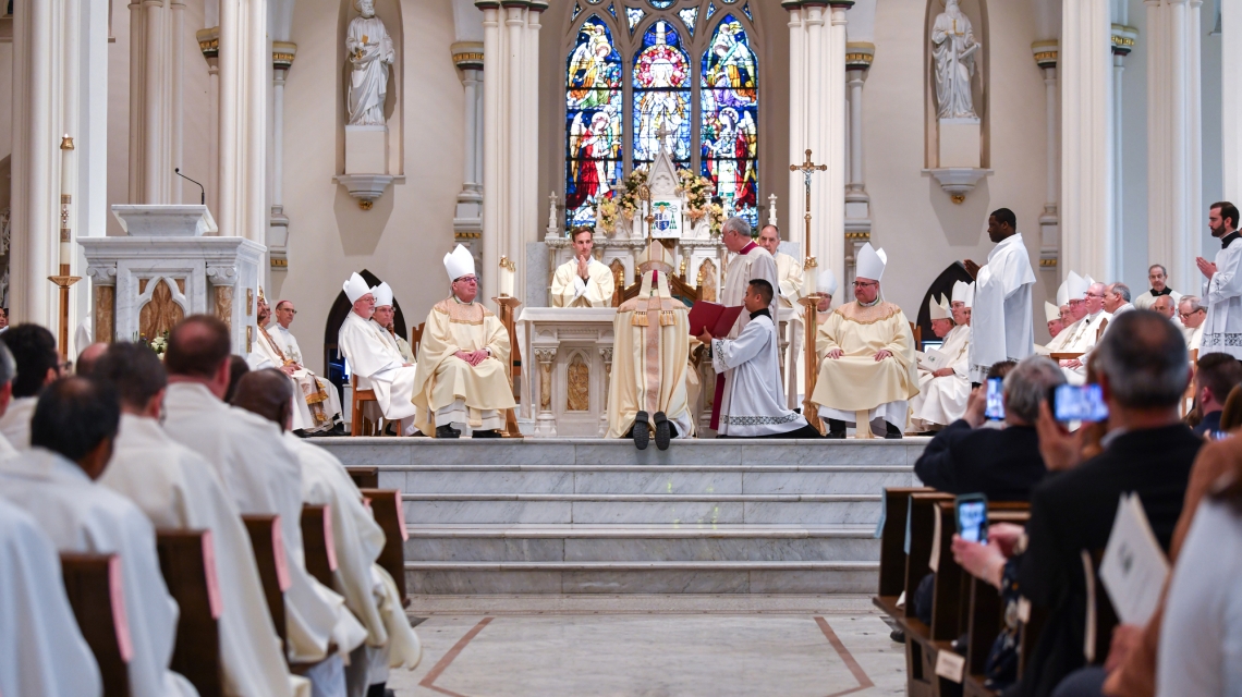 Cardinal O'Malley presents Bishop Ruggieri with the Book of the Gospels, a view from the back of the church.