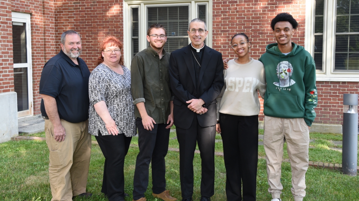Robert, Jennifer & Ryan Bussiere, Bishop James Ruggieri, and Mimosa Isimbi and her brother, Chelsea.