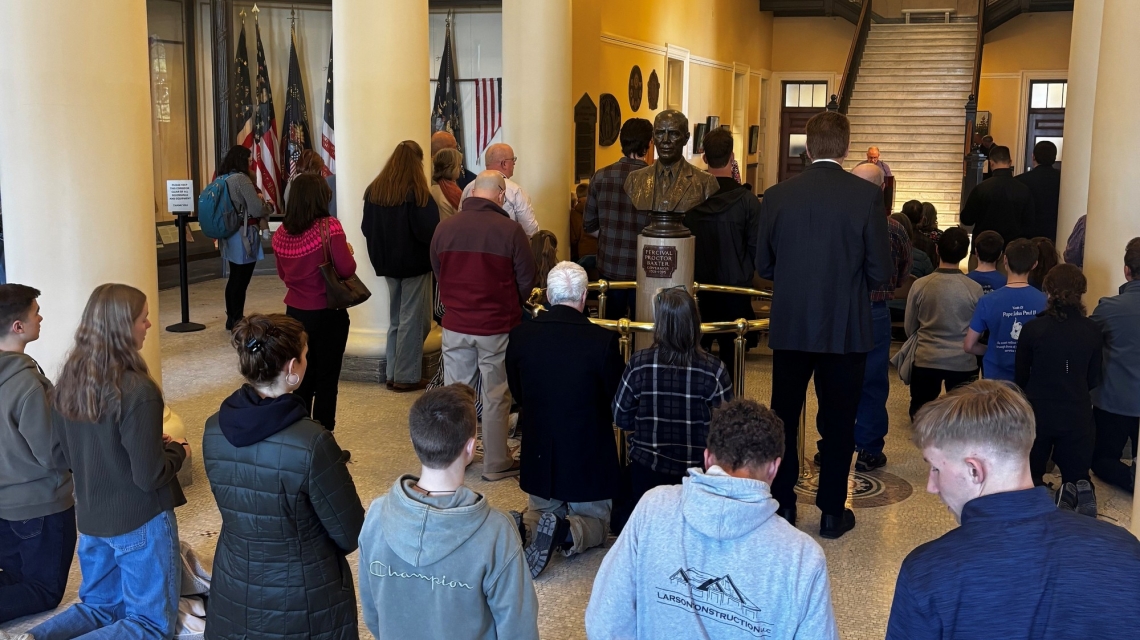 People kneeling and praying the Rosary at the State House