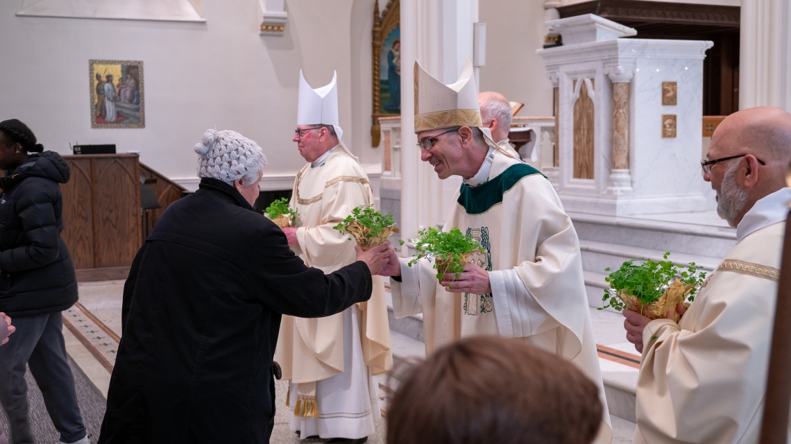 clergy handing out shamrocks after Mass