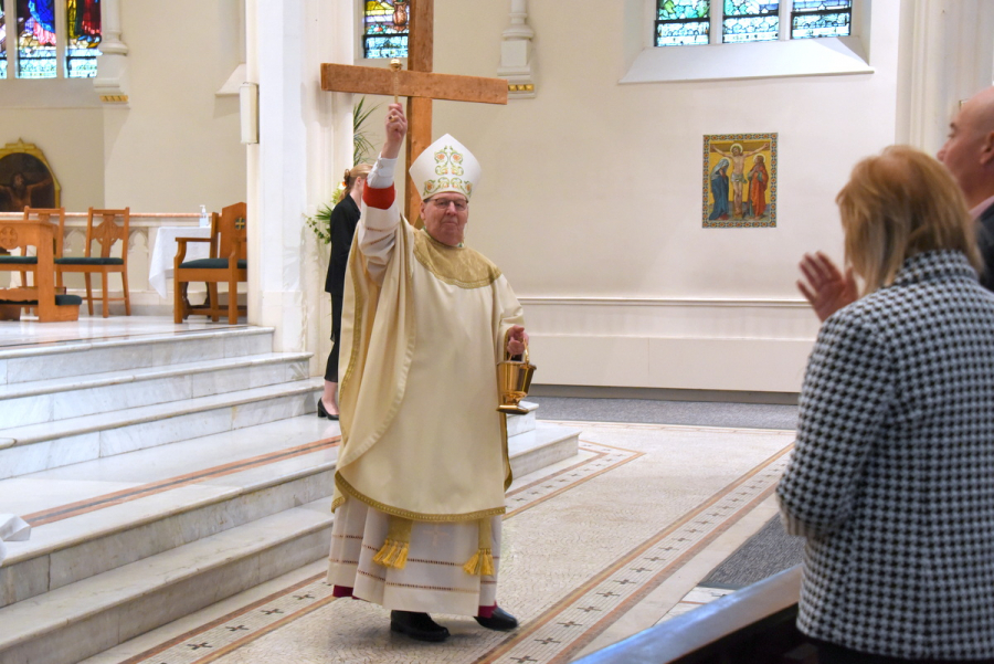 Bishop Robert Deeley sprinkles holy water on the congregation.