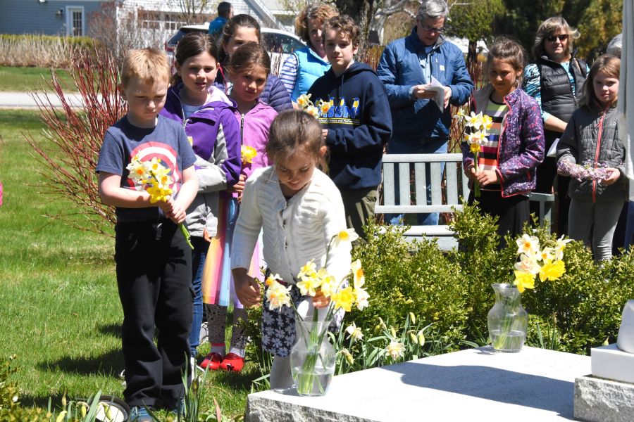 Placing flowers in vases at the foot of a statue of Mary