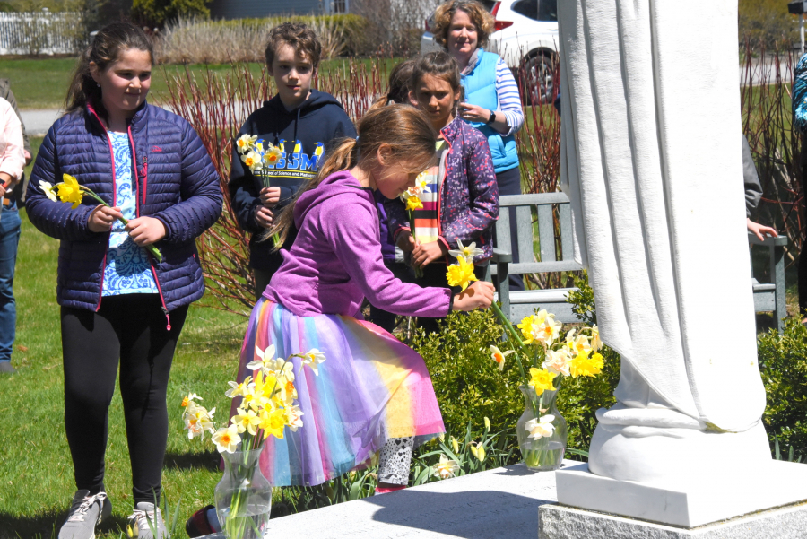 Placing flowers in vases at the foot of a statue of Mary