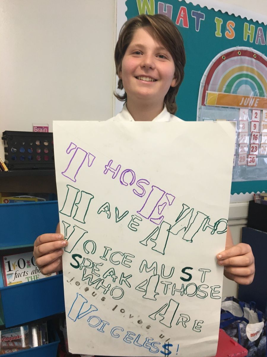 Teen holding up a poster