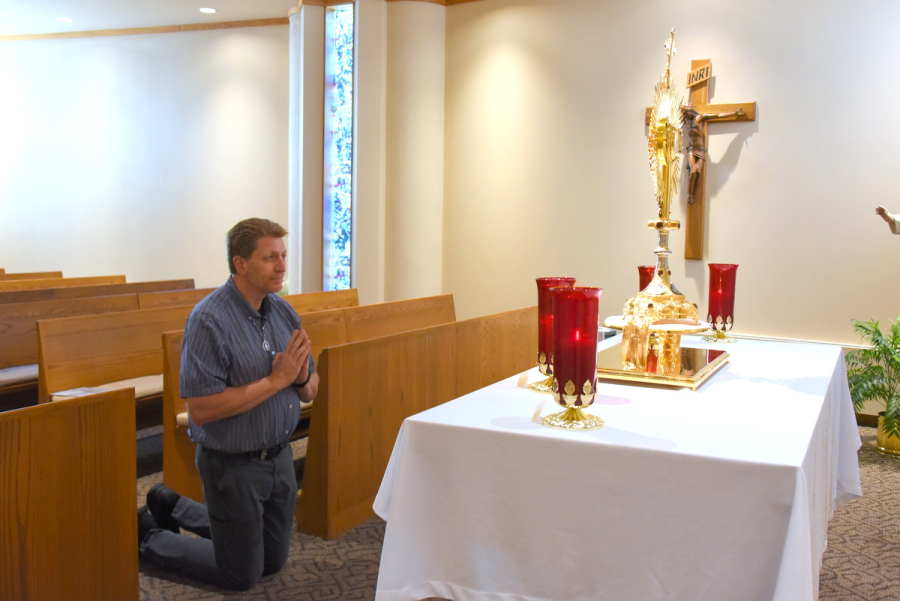 Brian Wilson kneels before the Blessed Sacrament.