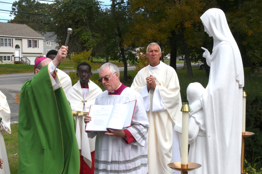 Bishp Deeley blesses a statue of St. Anne.