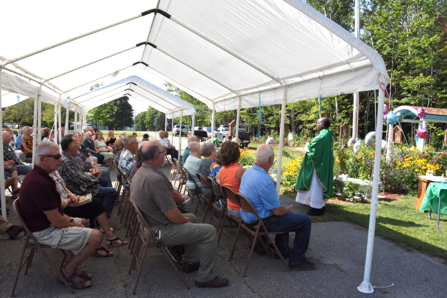 Parishioners gather for Mass outside St. Peter Church in East Millinocket.