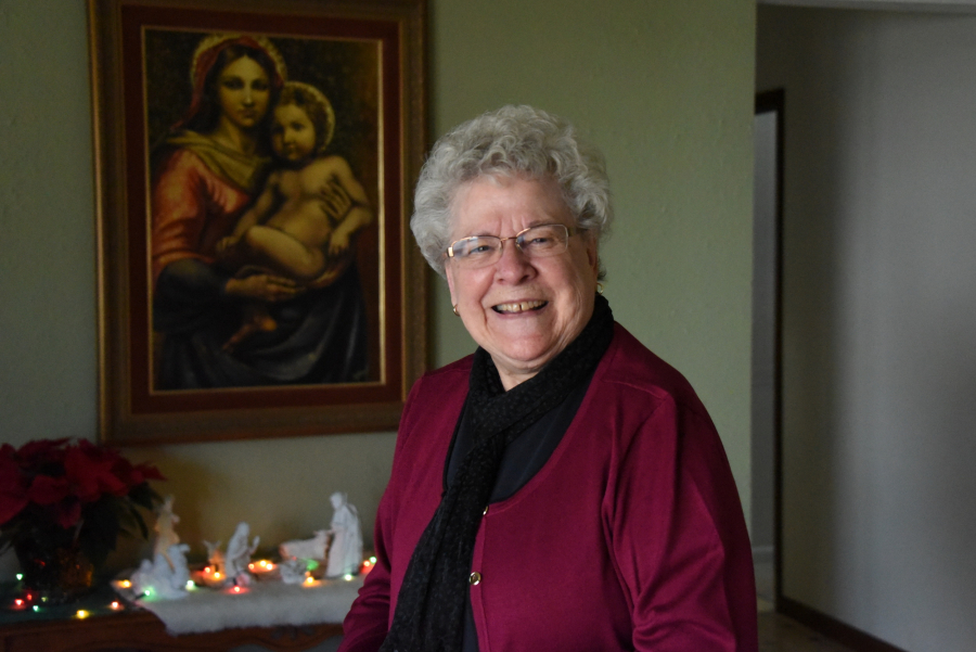 Jeannine DeRosby in her home near picture of Mary and Jesus