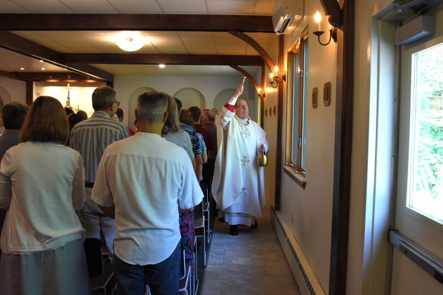 Bishop Deeley blesses the walls of the church.