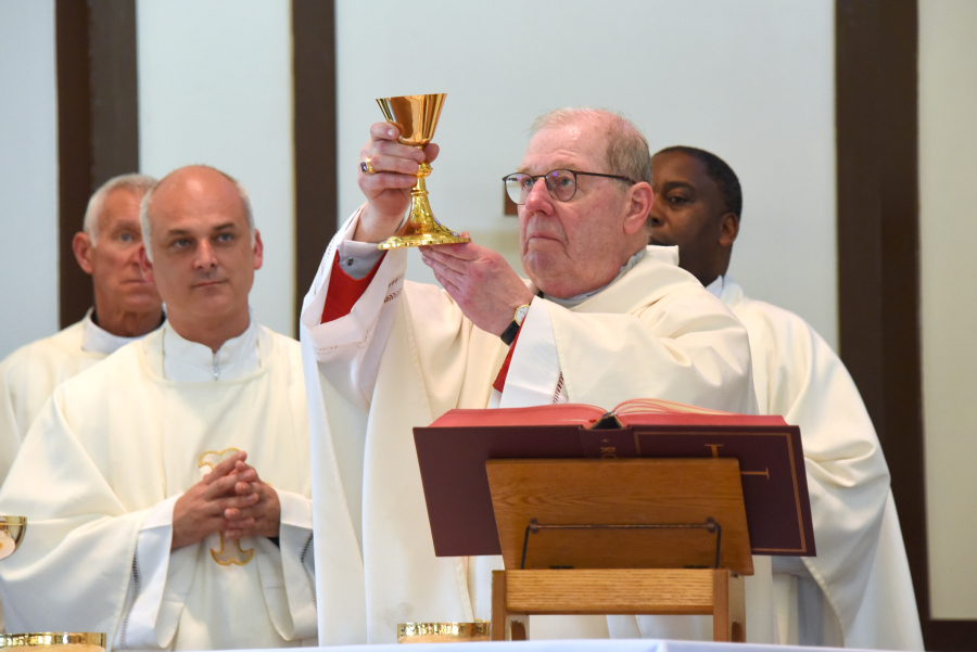 Bishop Robert Deeley holds up the chalice