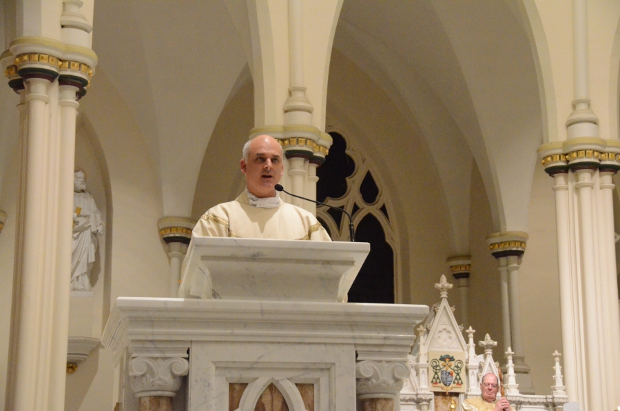 The bishop reads from a book from the altar