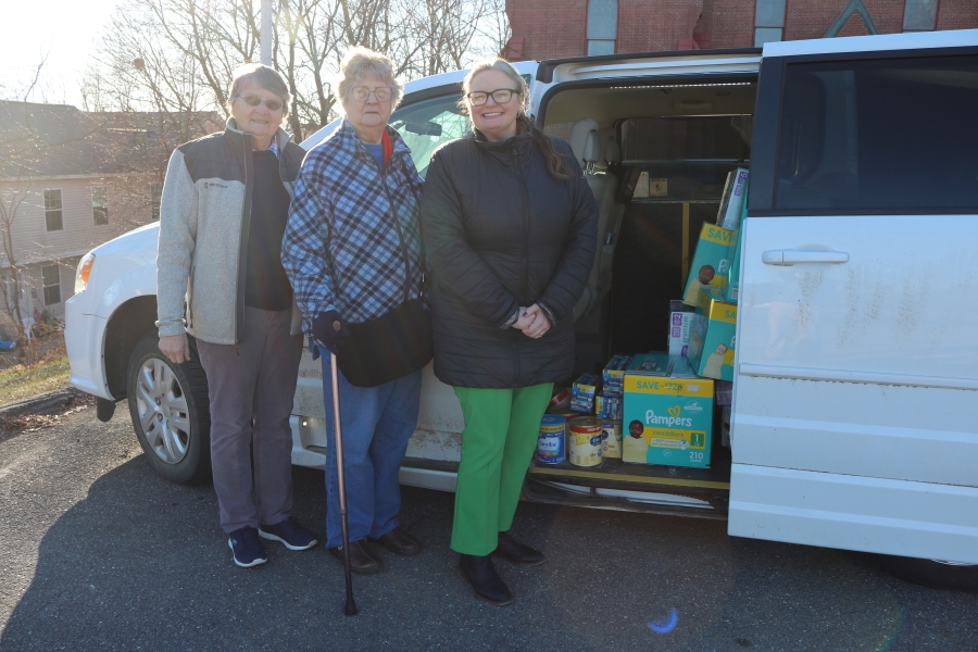 Three women standing outside a van