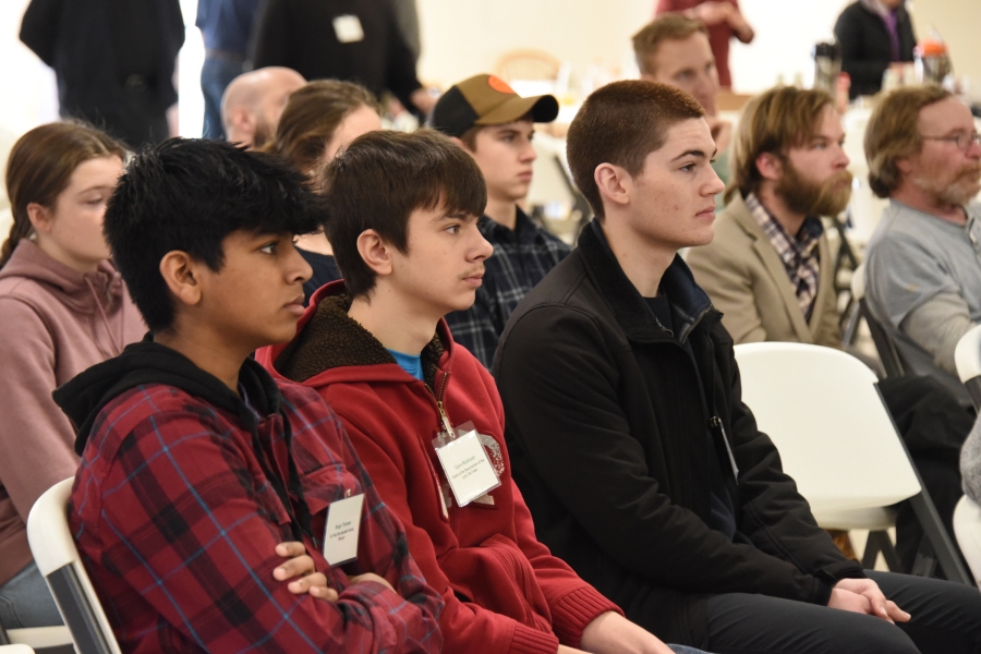 Teens sitting in a row.