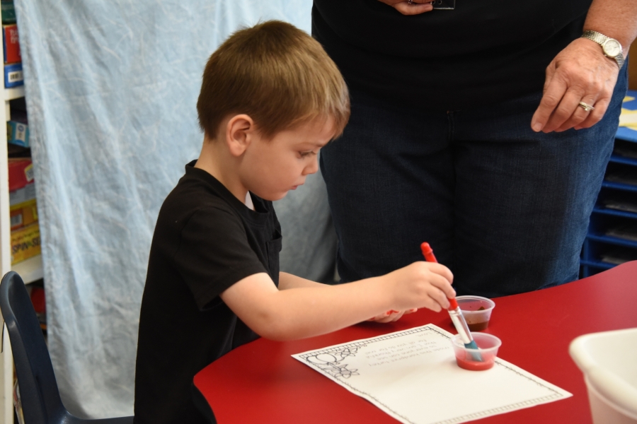 A preschooler makes a handprint turkey.