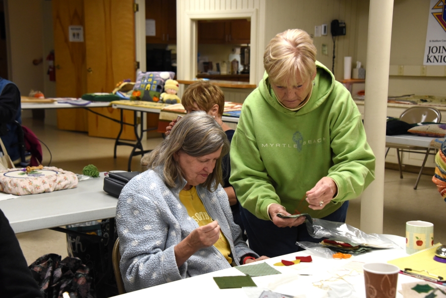 Two women discuss craft projects.