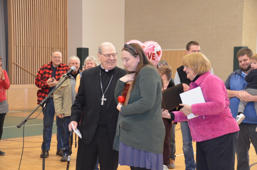 Bishop presenting a plaque to teacher