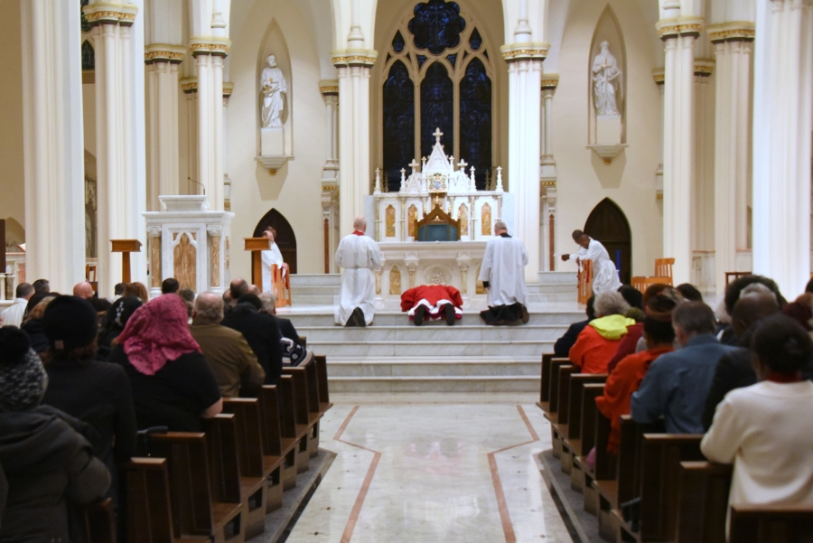 Bishop Deeley prostrates before the cross.