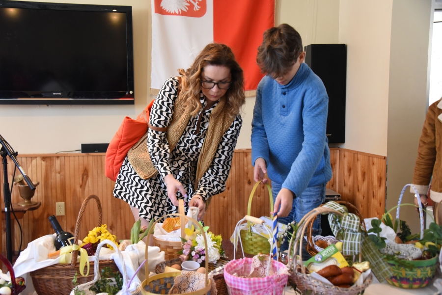 Woman and young man place Easter baskets on the table.