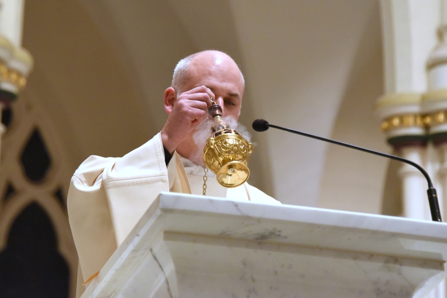 Father Seamus Griesbach incenses the Book of the Gospel.