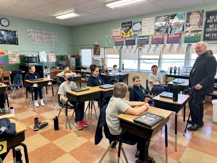 Bishop standing in front of students seated at desks