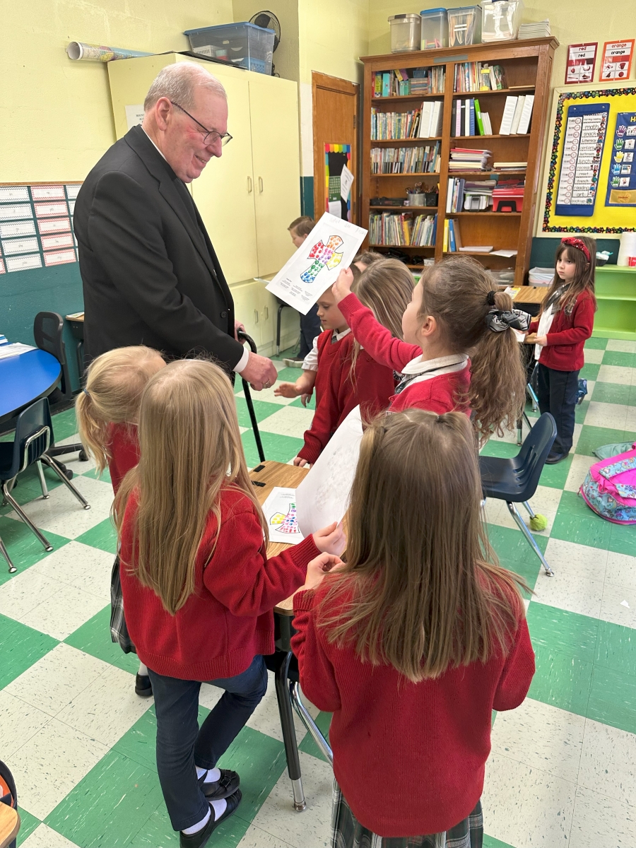 Student shows bishop a piece of her artwork