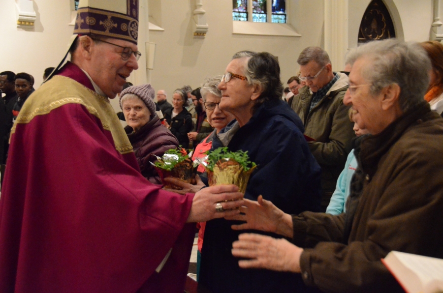 Bishop Deeley handing out pots of clovers to parishoners