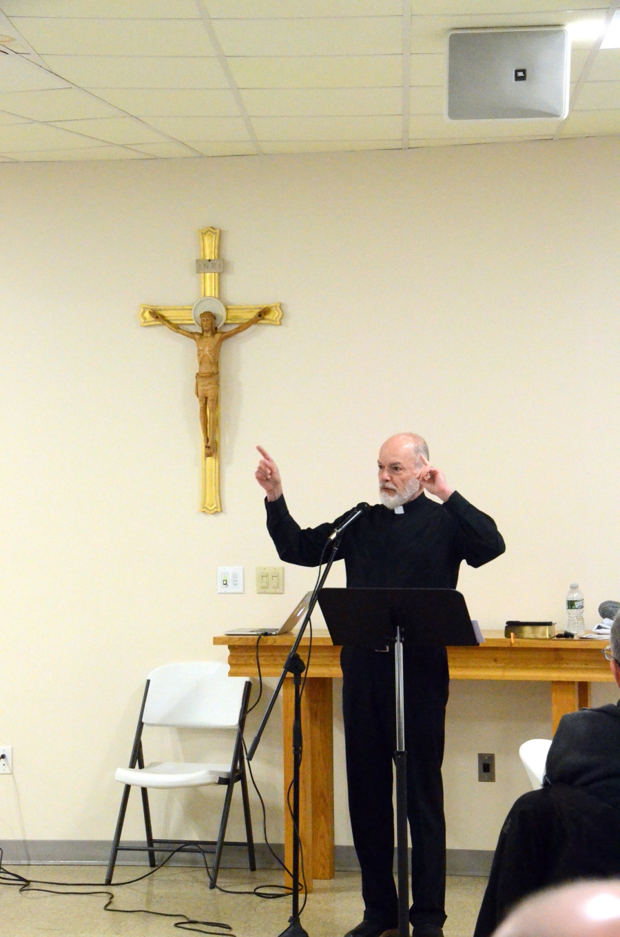 priest speaking at microphone