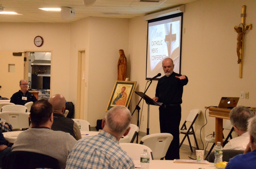 priest speaking to group of men