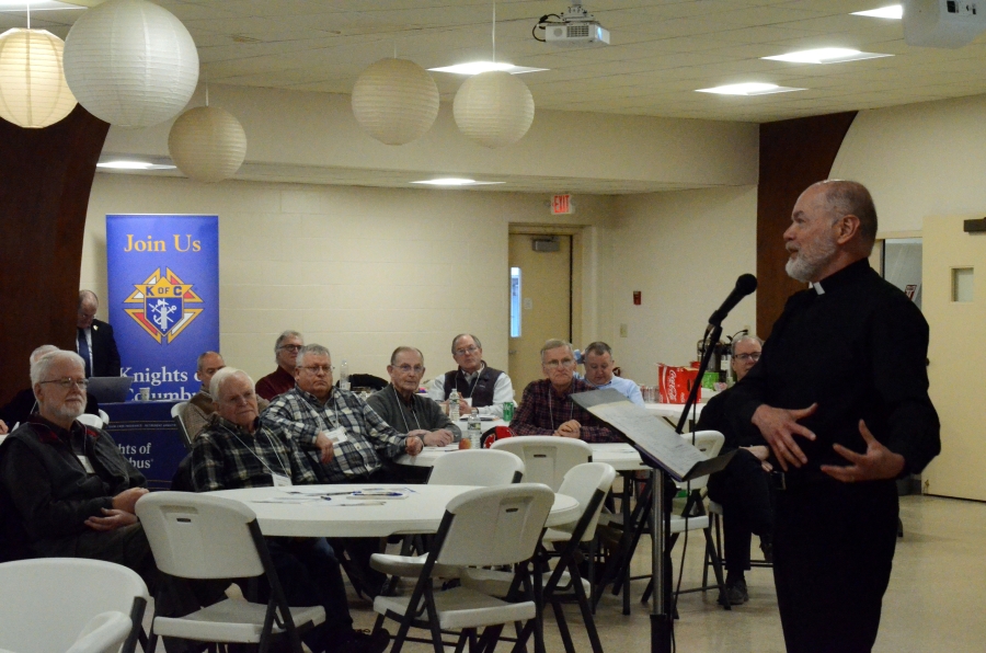 Priest speaking to group of men