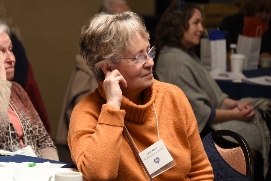 Woman wearing an orange sweater and smiling.