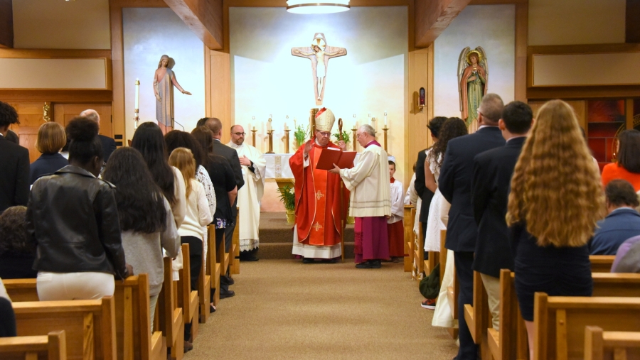 Bishop Robert Deeley prays over the people to be confirmed.