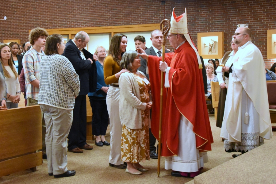 Bishop Deeley offers the sacrament of confirmation to an individual.