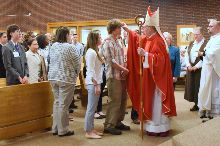 Bishop Deeley offers the sacrament of confirmation to an individual.