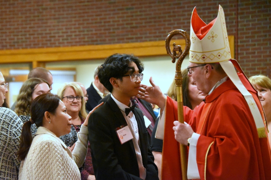 Bishop Deeley offers the sacrament of confirmation to an individual.