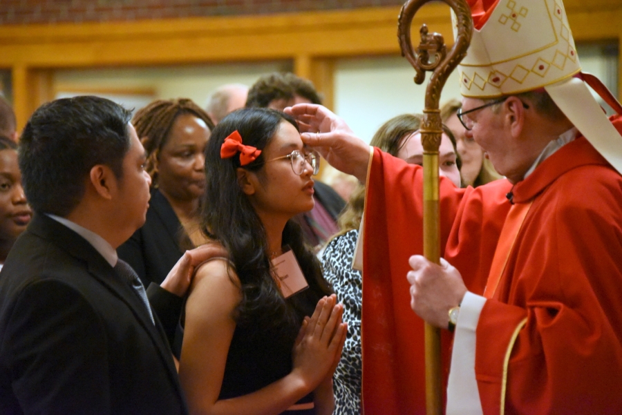 Bishop Deeley offers the sacrament of confirmation to an individual.