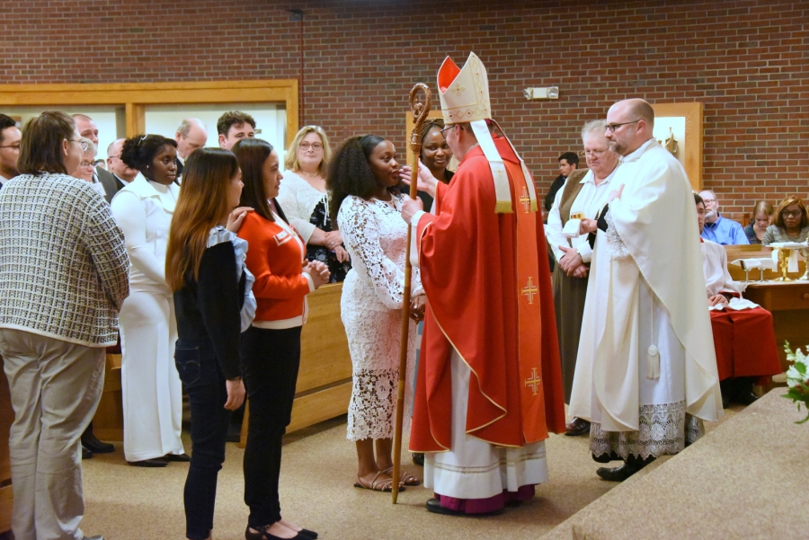 Bishop Deeley offers the sacrament of confirmation to an individual.