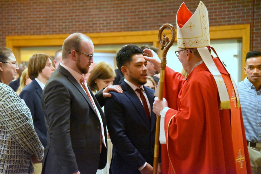 Bishop Deeley offers the sacrament of confirmation to an individual.