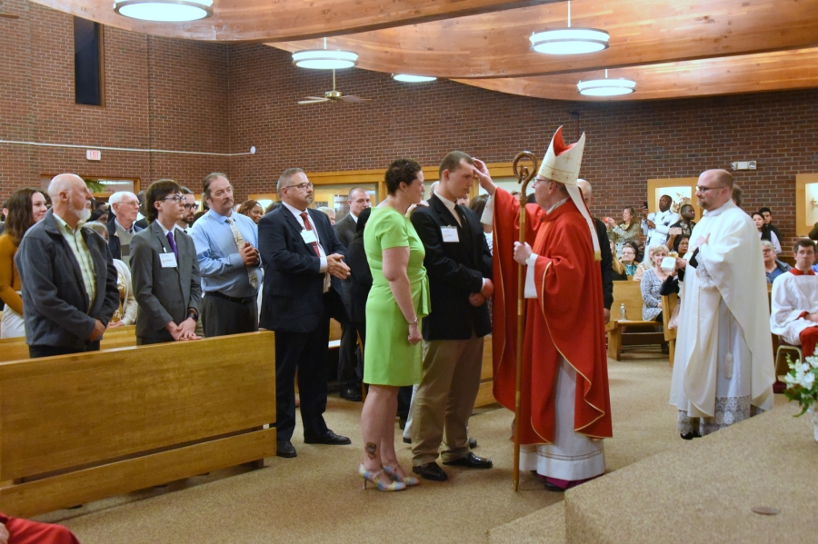 Bishop Deeley offers the sacrament of confirmation to an individual.