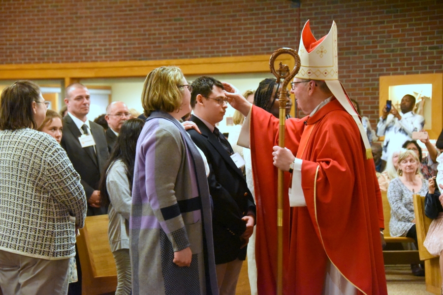 Bishop Deeley offers the sacrament of confirmation to an individual.