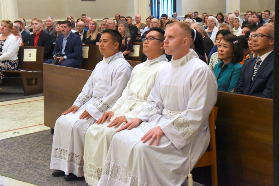 The three ordinands listen to the homily.