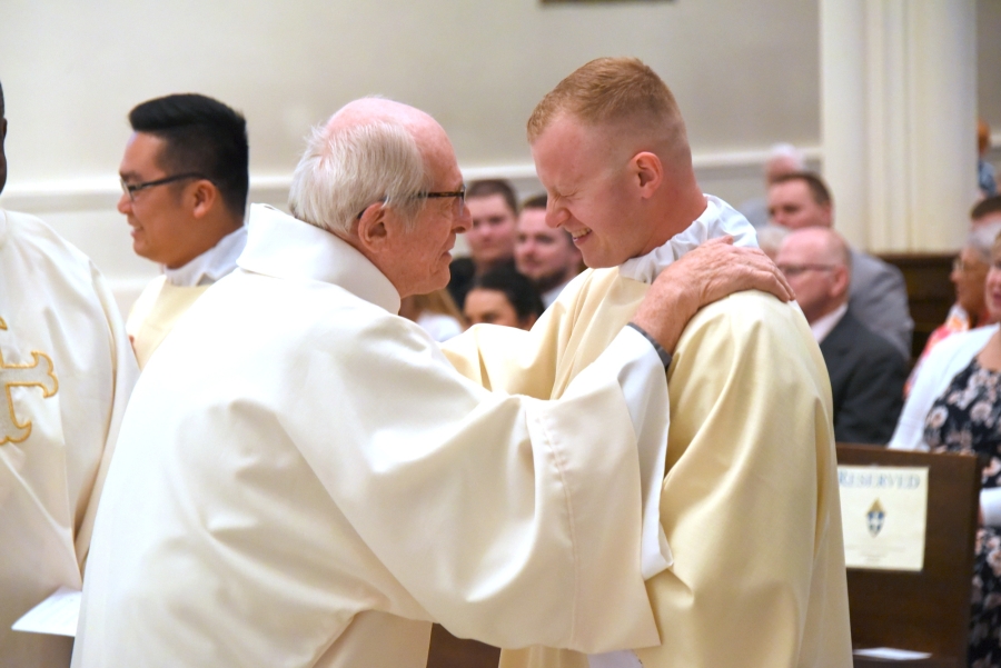 Deacon Guerin gives Deacon Erin Donlon a hug (fraternal kiss of peace)