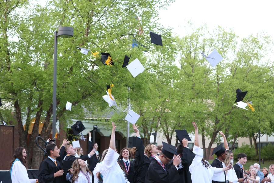 Class of 2024 throwing their caps up in the air 