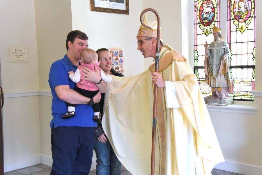 Greeting a couple and their child after Mass.