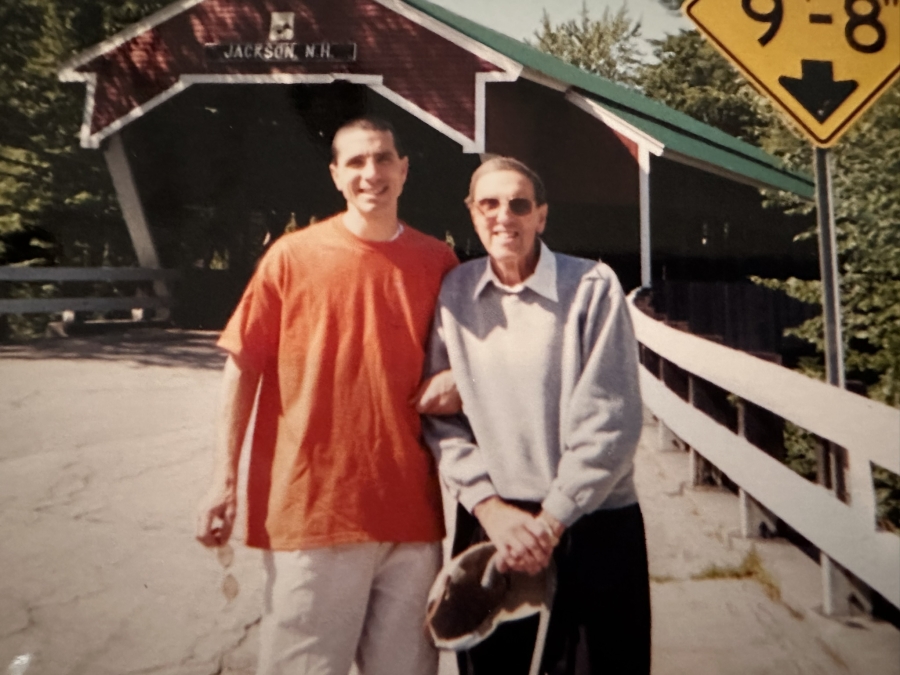 two people standing near a covered bridge