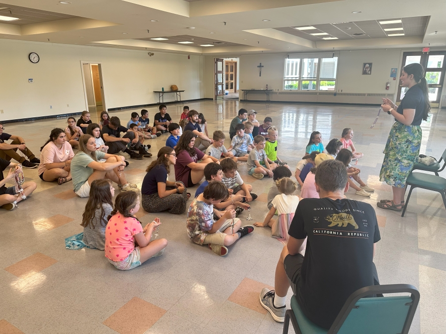 campers learning the rosary inside