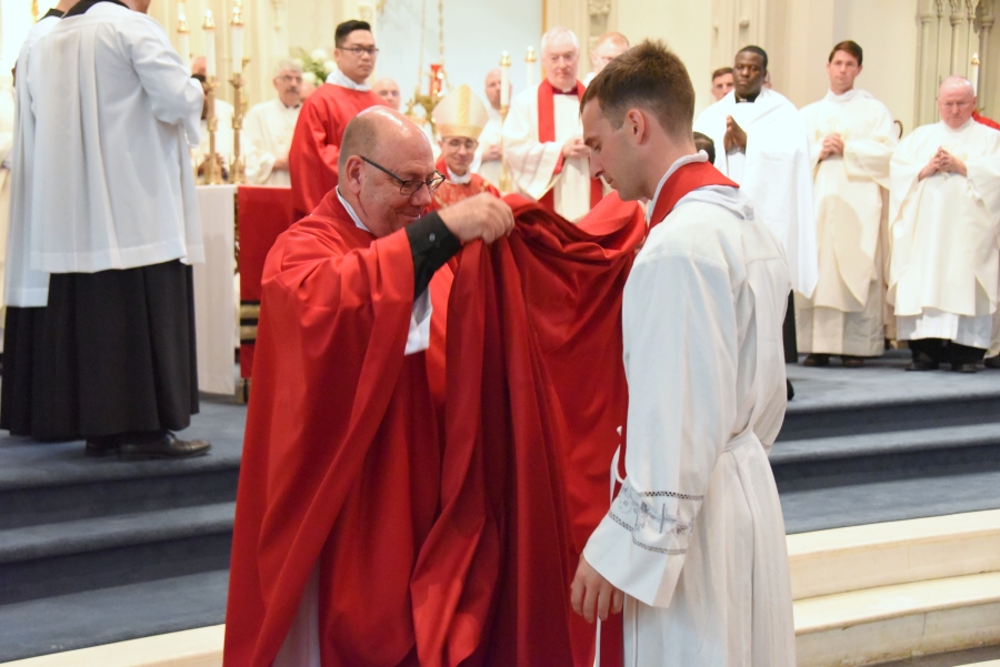 Father Wilfred Labbe vests Father Matthew Valles.