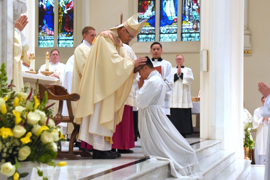 Bishop James Ruggieri lays hands on Thanh Duc Pham.