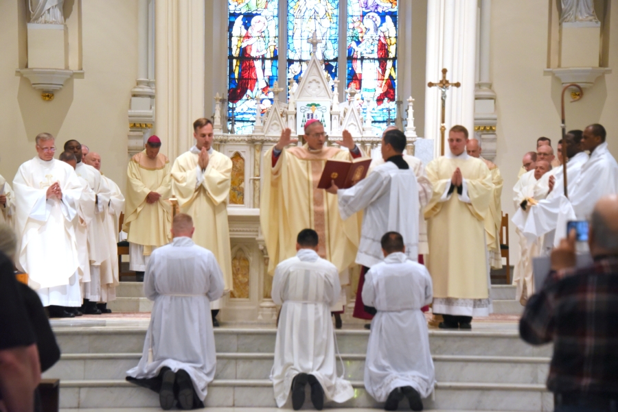 Bishop James Ruggieri prays the Prayer of Ordination for Erin Donlon, Thanh Duc Pham, and Hoa Tien Nguyen