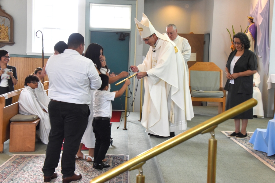 Members of the Majano Family present the bishop with Rosary beads